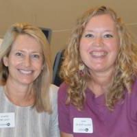 two blonde women smile and pose for picture